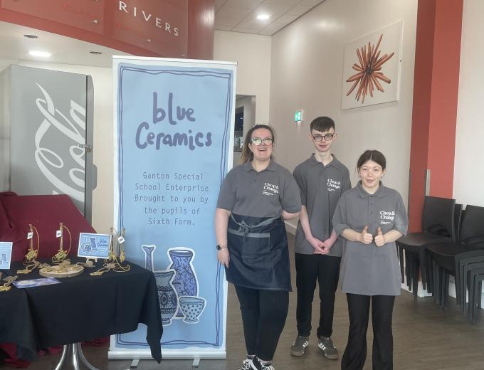 Three students from Ganton School stood smiling next to their Blue Ceramics stand.