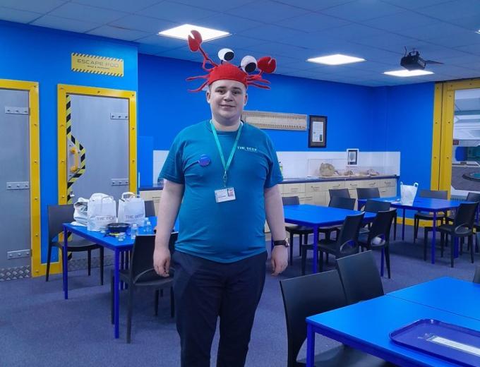 Jacob stood smiling in one of The Deep's classrooms, with a crab hat on his head.