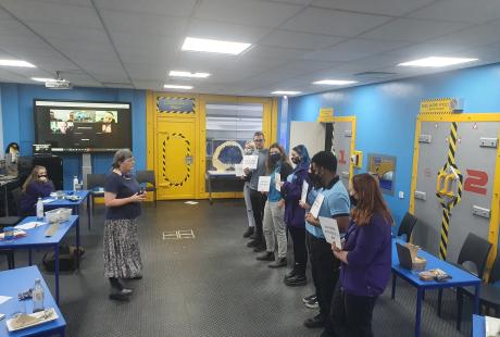 People in a classroom holding up certificates