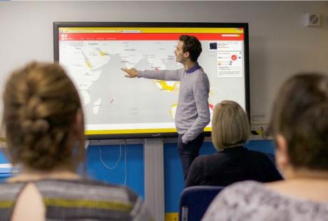 Man pointing at a map on a screen